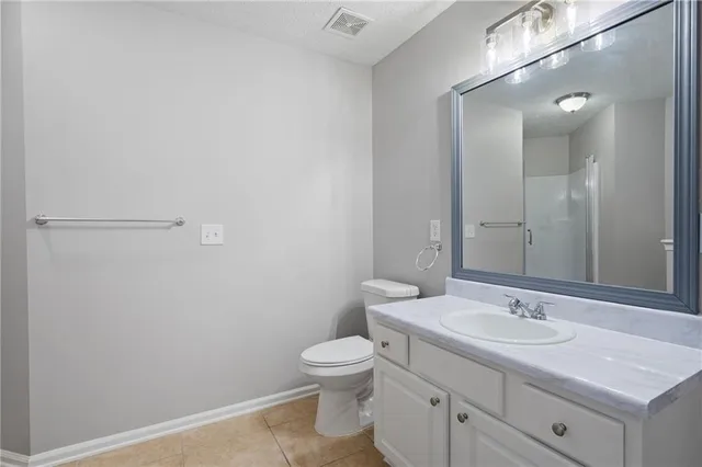 a bathroom with a granite countertop sink a toilet and a mirror