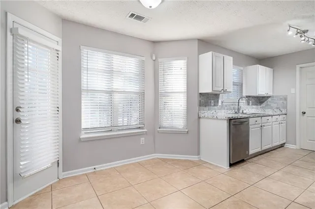 a kitchen with a white cabinets and window