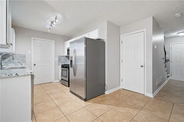a kitchen with granite countertop a refrigerator and a sink