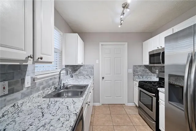 a kitchen with a sink stove and refrigerator
