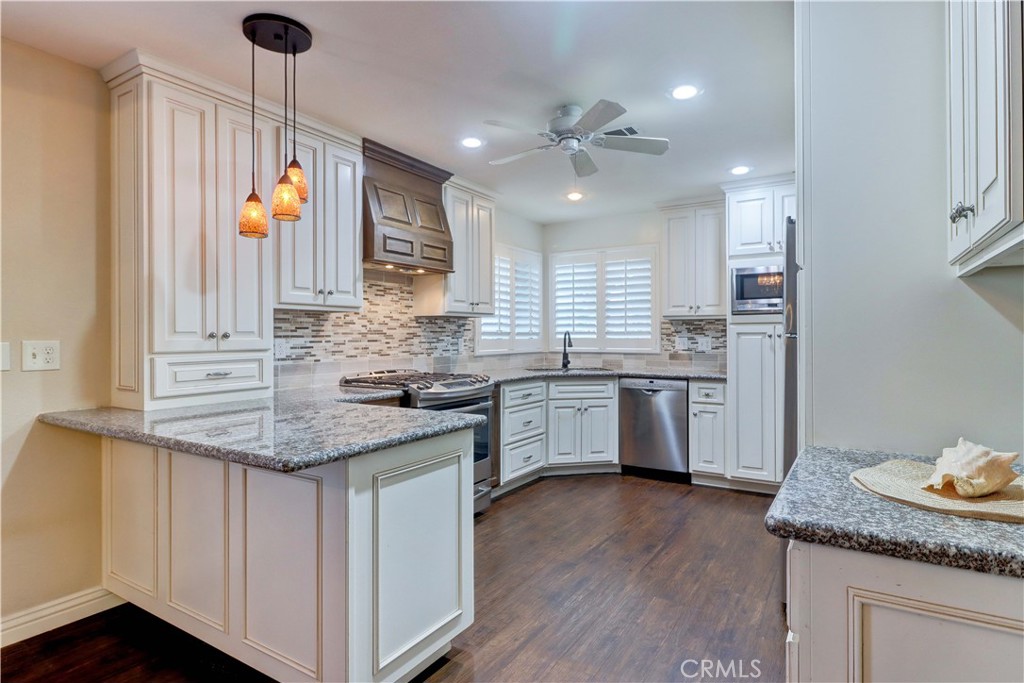 2509 View Lake Santa Ana, CA 92705 - Photo 20 of 74 a kitchen with stainless steel appliances granite countertop a sink cabinets and wooden floor