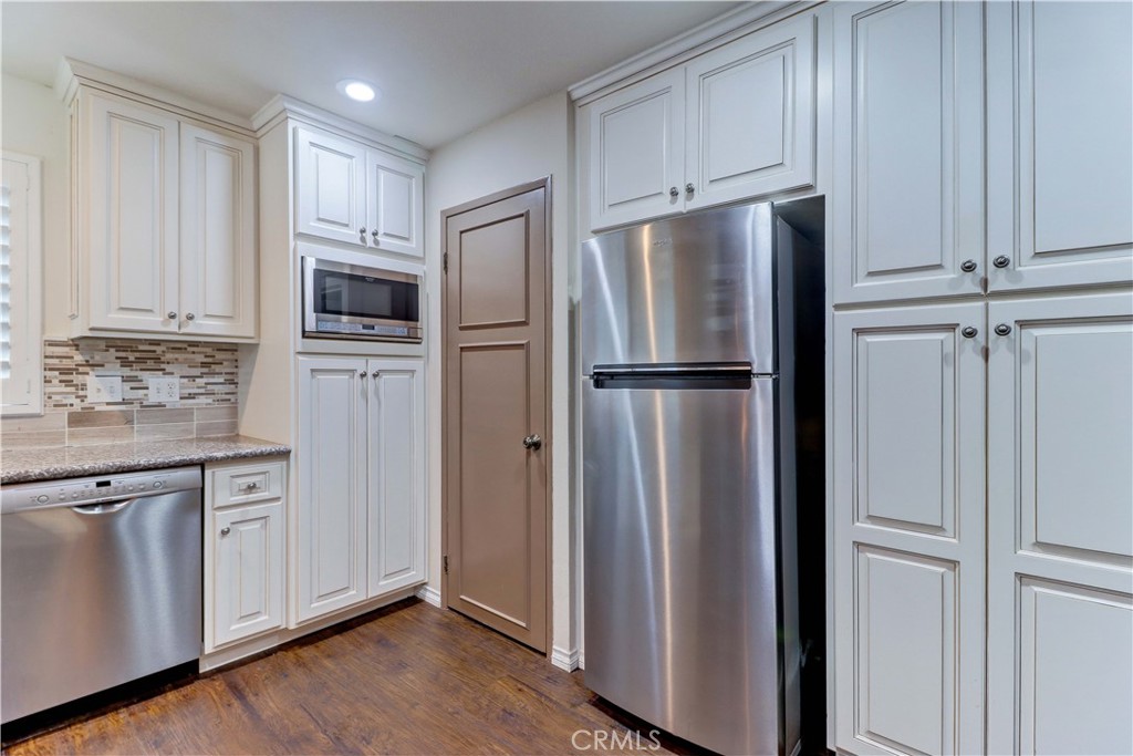 2509 View Lake Santa Ana, CA 92705 - Photo 26 of 74 a kitchen with stainless steel appliances granite countertop a refrigerator and white cabinets