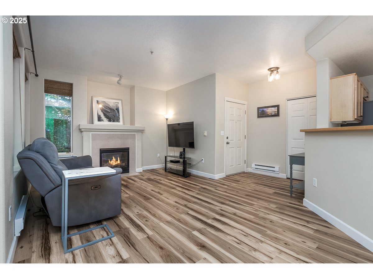 14575 Southwest Magpie Lane, Unit 102 Beaverton, OR 97007 - Photo 11 of 30 a living room with furniture a fireplace and a flat screen tv