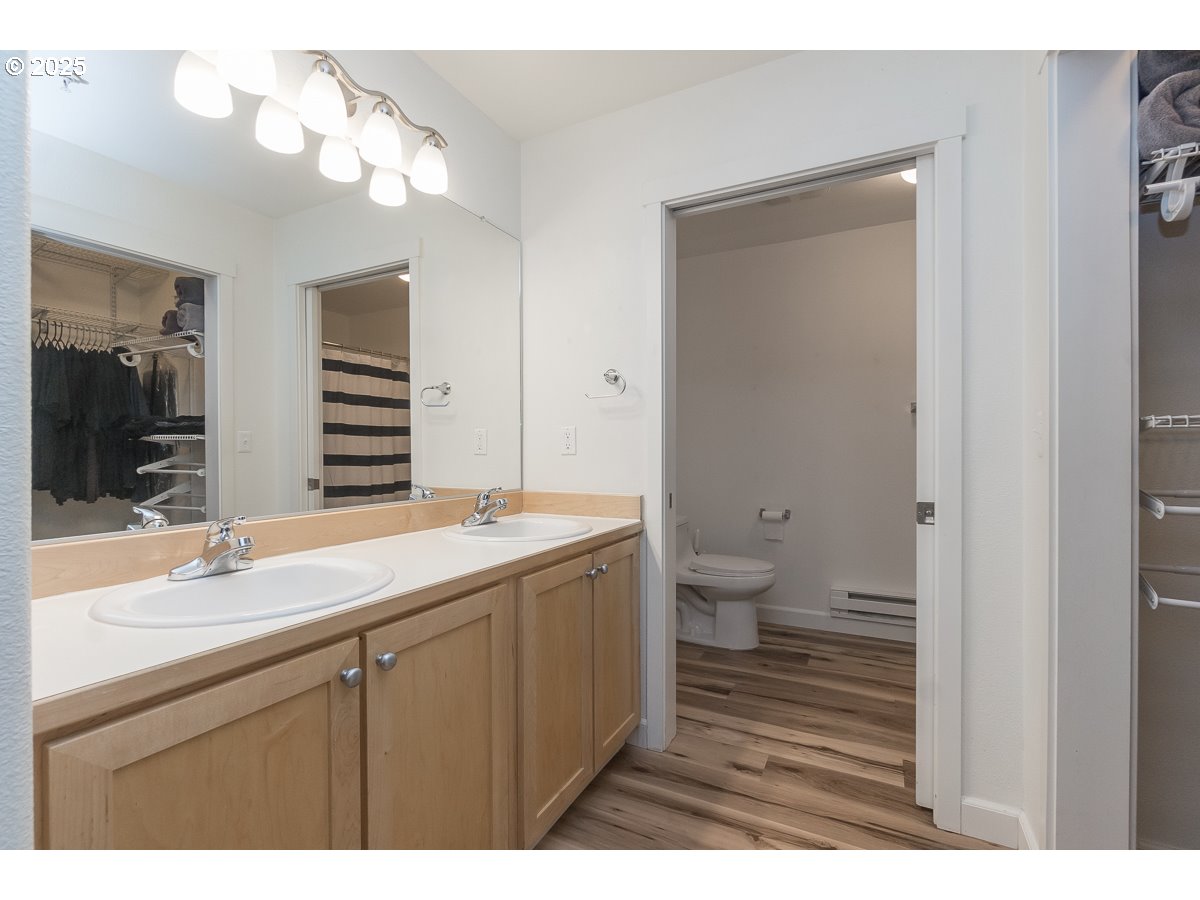 14575 Southwest Magpie Lane, Unit 102 Beaverton, OR 97007 - Photo 25 of 30 a bathroom with a sink a toilet and a large mirror