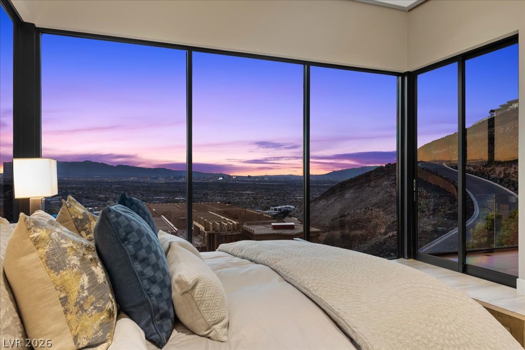 657 Ridgestone Rim Court Henderson, NV 89012 - Photo 32 of 97 Dramatic floor-to-ceiling windows frame panoramic valley and mountain views from this elevated bedroom.
