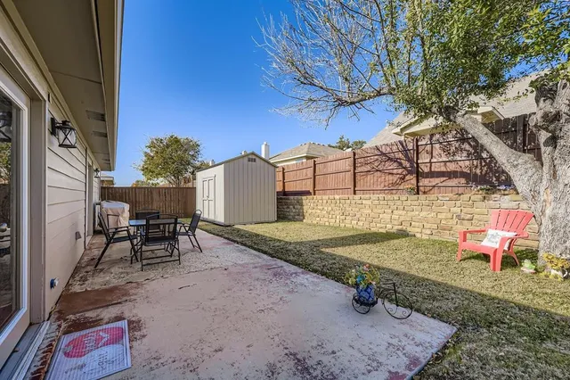 a backyard of a house with table and chairs