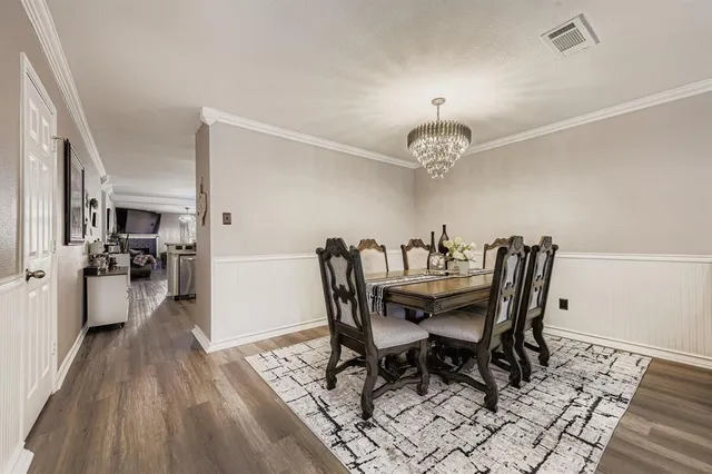 a dining room with furniture a chandelier and wooden floor