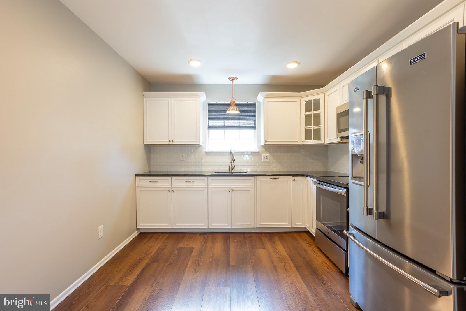 143 Midland Road Glen Burnie, MD 21060 - Photo 14 of 44 a kitchen with granite countertop a refrigerator and a sink