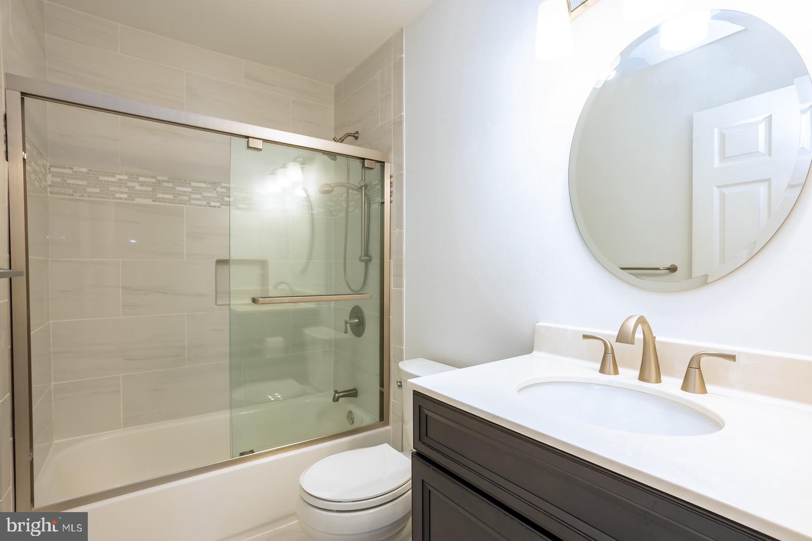 143 Midland Road Glen Burnie, MD 21060 - Photo 16 of 44 a bathroom with a granite countertop sink toilet and shower