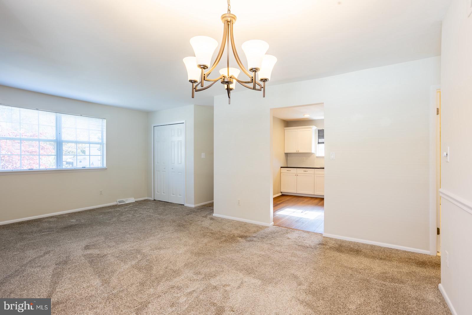 143 Midland Road Glen Burnie, MD 21060 - Photo 5 of 44 an empty room with chandelier fan and windows