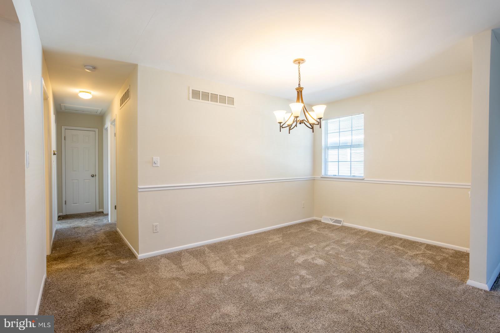 143 Midland Road Glen Burnie, MD 21060 - Photo 10 of 44 an empty room with chandelier fan and windows