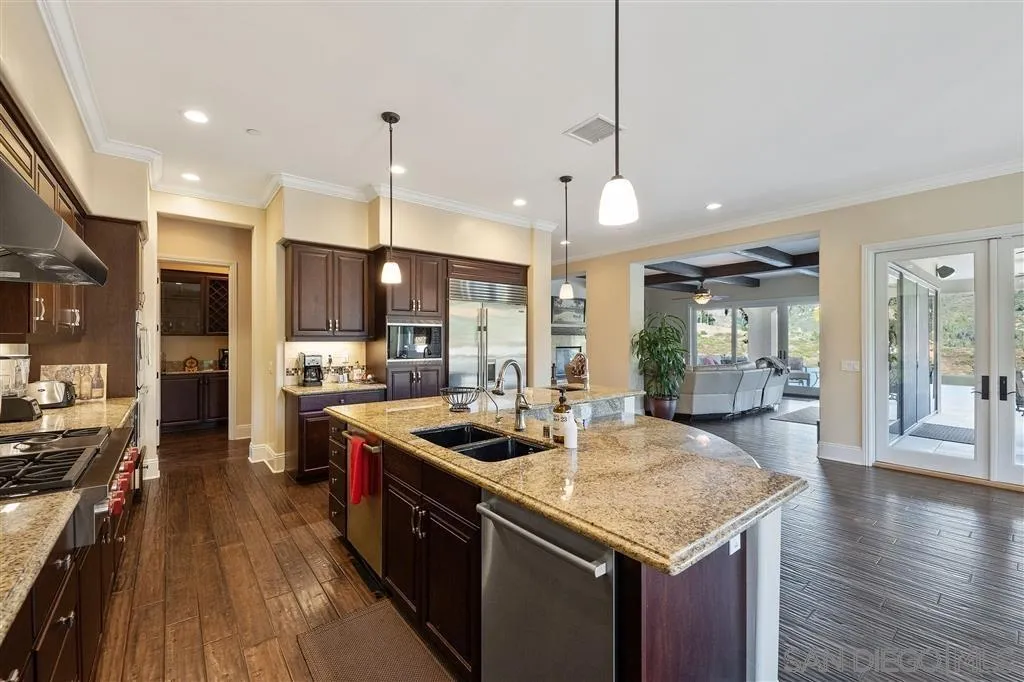 14480 Cheyenne Trail Poway, CA 92064 - Photo 15 of 23 a kitchen with stainless steel appliances granite countertop a sink a stove and a wooden floors