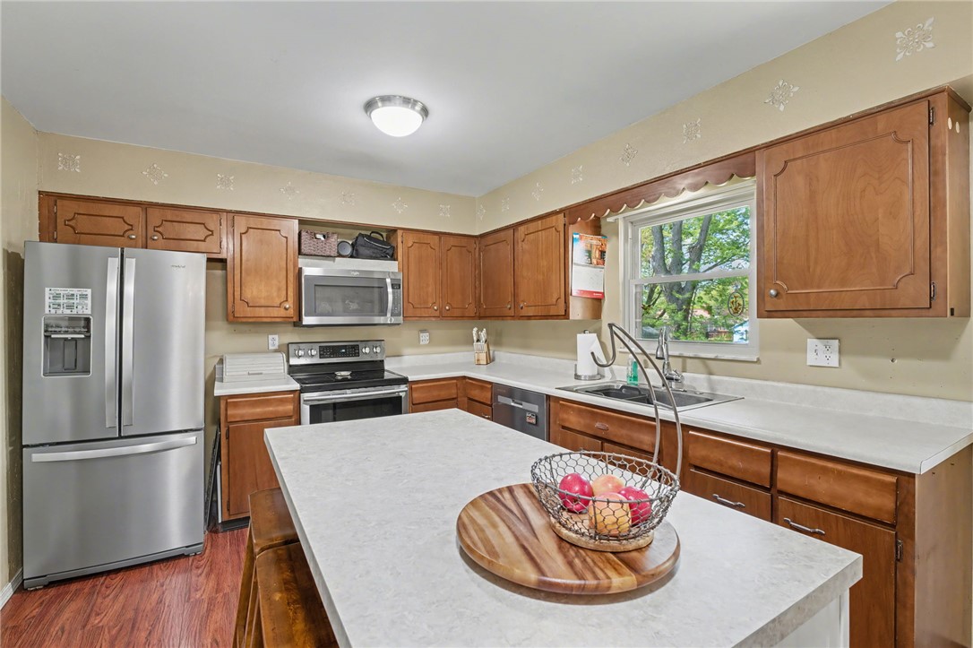 4919 Silver Arrow Drive Riverside, OH 45424 - Photo 15 of 57 This kitchen features rich wooden cabinetry and a bright window overlooking lush greenery.