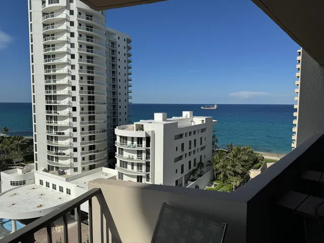 a view of a balcony with wooden floor and lake view