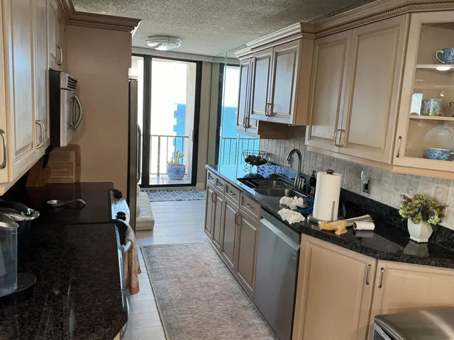a kitchen with a sink stove top oven and glass door