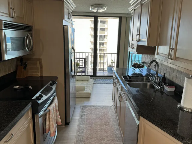 a kitchen with stainless steel appliances granite countertop a sink stove and cabinets