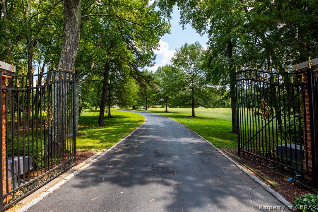 Paved driveway at security gate entrance.  This is the house side of Shandan Farm.  Paved drive leads to circular drive and parking court in front of the home and Carriage house.