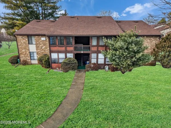 a front view of a house with a garden and trees