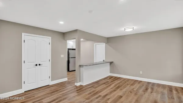 a view of empty room with wooden floor