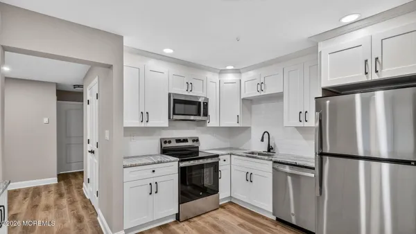 a kitchen with white cabinets and stainless steel appliances