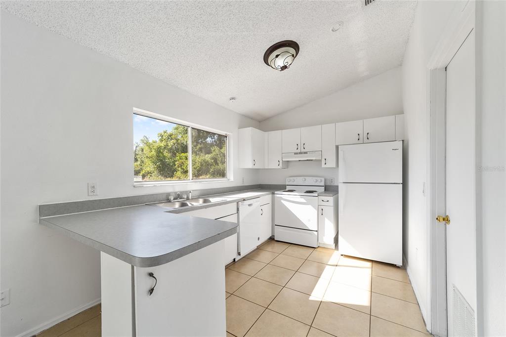 8 Ash Pass Run Ocala, FL 34472 - Photo 13 of 33 a kitchen with a sink a refrigerator and window