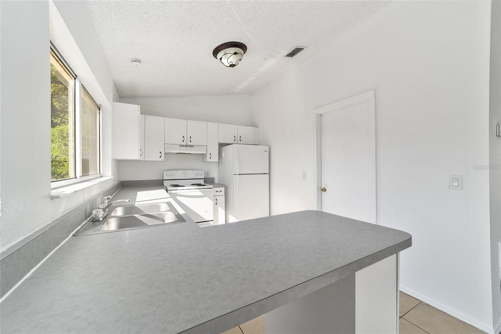 8 Ash Pass Run Ocala, FL 34472 - Photo 14 of 33 a kitchen with kitchen island a stove a sink and a window