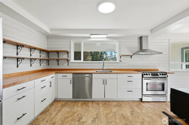 a kitchen with granite countertop a sink stainless steel appliances and cabinets