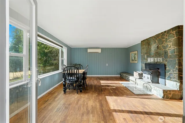a dining room with furniture a fireplace and wooden floor