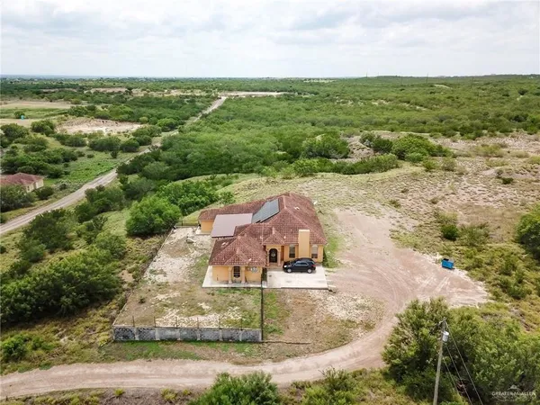 an aerial view of residential houses with outdoor space and trees