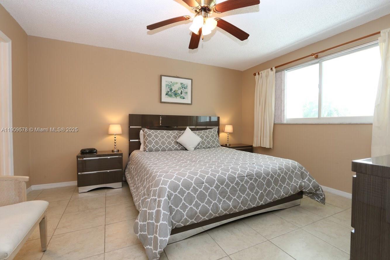17800 North Bay Road, Unit 404 Sunny Isles Beach, FL 33160 - Photo 13 of 36 a bedroom with a bed and a chandelier