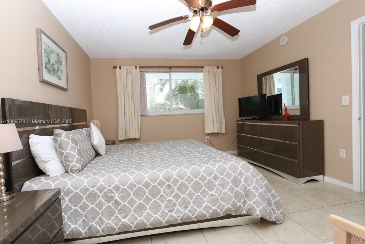 17800 North Bay Road, Unit 404 Sunny Isles Beach, FL 33160 - Photo 14 of 36 a bedroom with a large bed and a flat tv screen