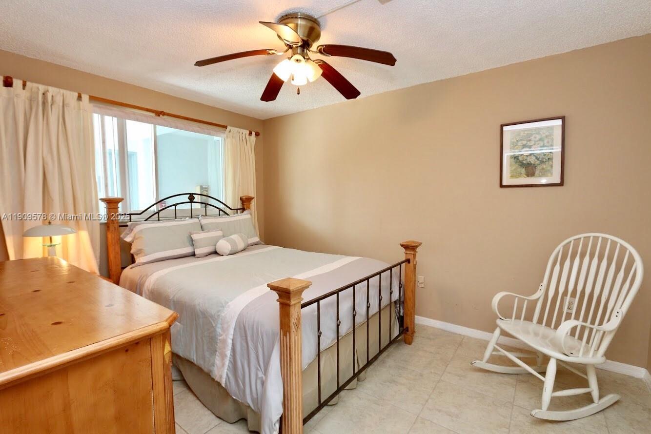 17800 North Bay Road, Unit 404 Sunny Isles Beach, FL 33160 - Photo 17 of 36 a bedroom with a bed and a chair