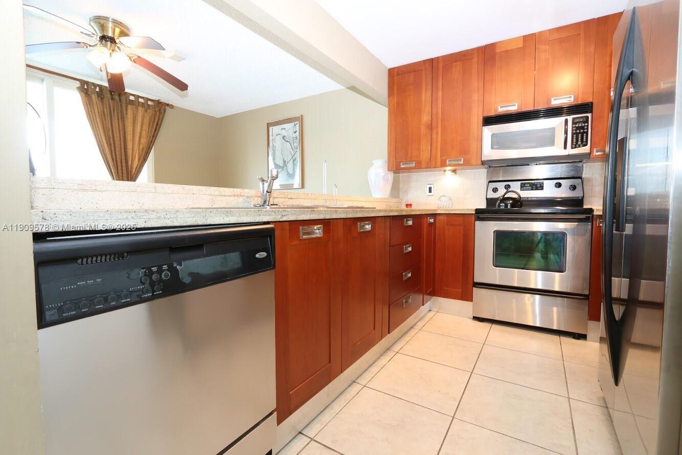17800 North Bay Road, Unit 404 Sunny Isles Beach, FL 33160 - Photo 3 of 36 a kitchen with stainless steel appliances granite countertop a sink stove and refrigerator