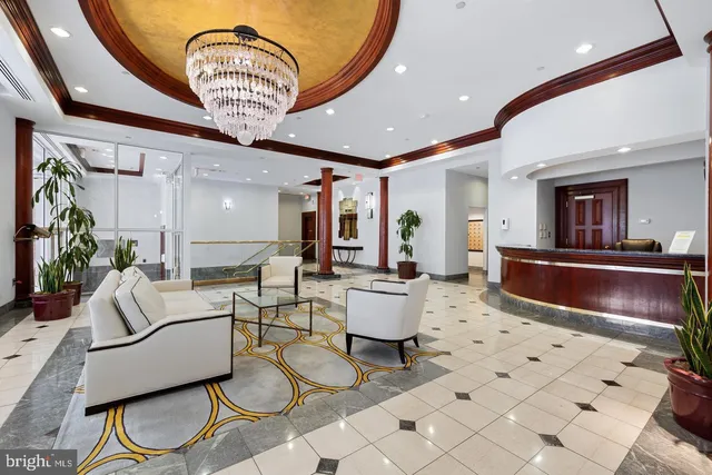 a living room with furniture and a chandelier