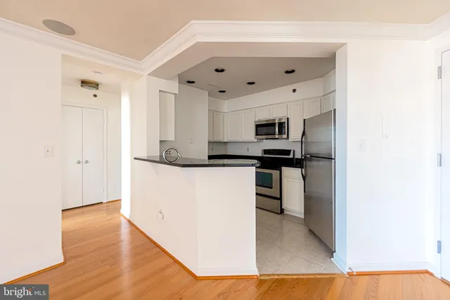 a kitchen with stainless steel appliances granite countertop a refrigerator and a stove