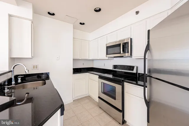 a kitchen with stainless steel appliances granite countertop a stove and a microwave