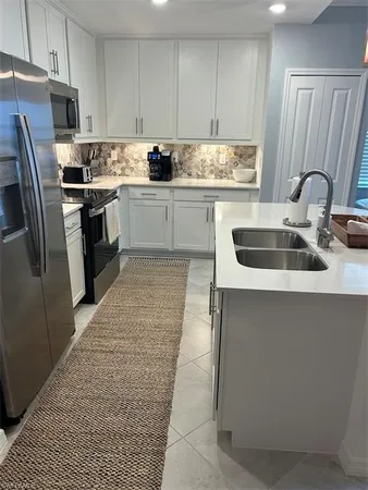 a kitchen with stainless steel appliances granite countertop a refrigerator sink and cabinets