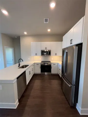 a large kitchen with kitchen island a sink stainless steel appliances and cabinets
