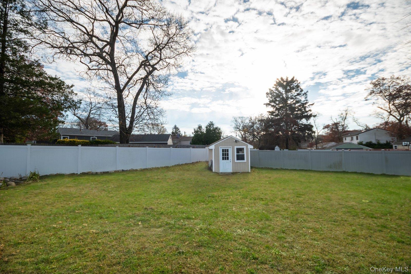 277 Horseblock Road Farmingville, NY 11738 - Photo 24 of 28 Fenced backyard featuring a storage unit