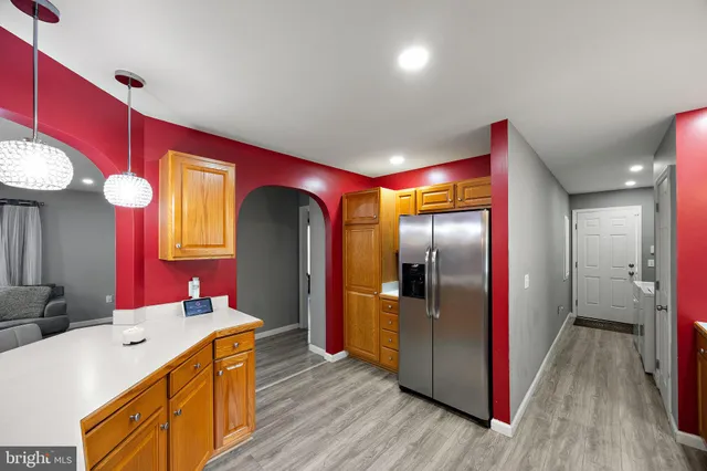 a kitchen with stainless steel appliances granite countertop a refrigerator a sink and wooden floor