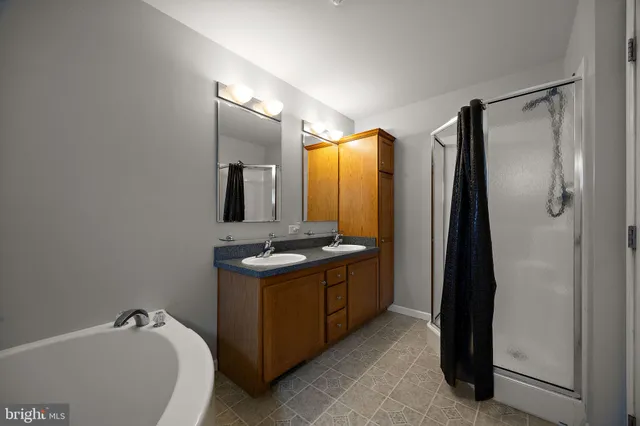 a bathroom with a tub sink and mirror