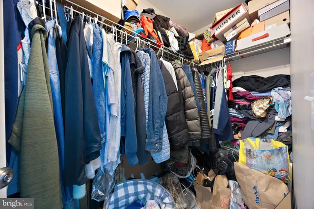 a view of walk in closet with clothes and shoes
