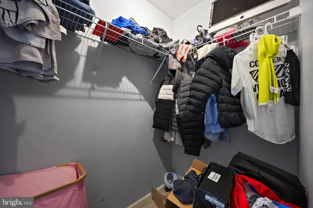 a view of walk in closet with clothes and shoes