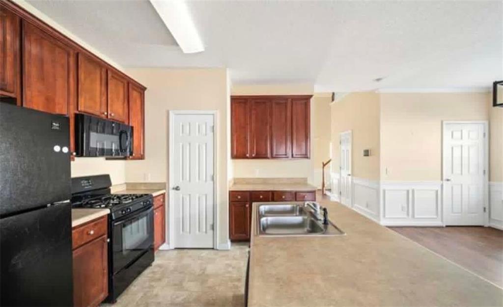 2162 Capella Circle Southwest Atlanta, GA 30331 - Photo 5 of 11 a kitchen with granite countertop a stove a sink and a refrigerator