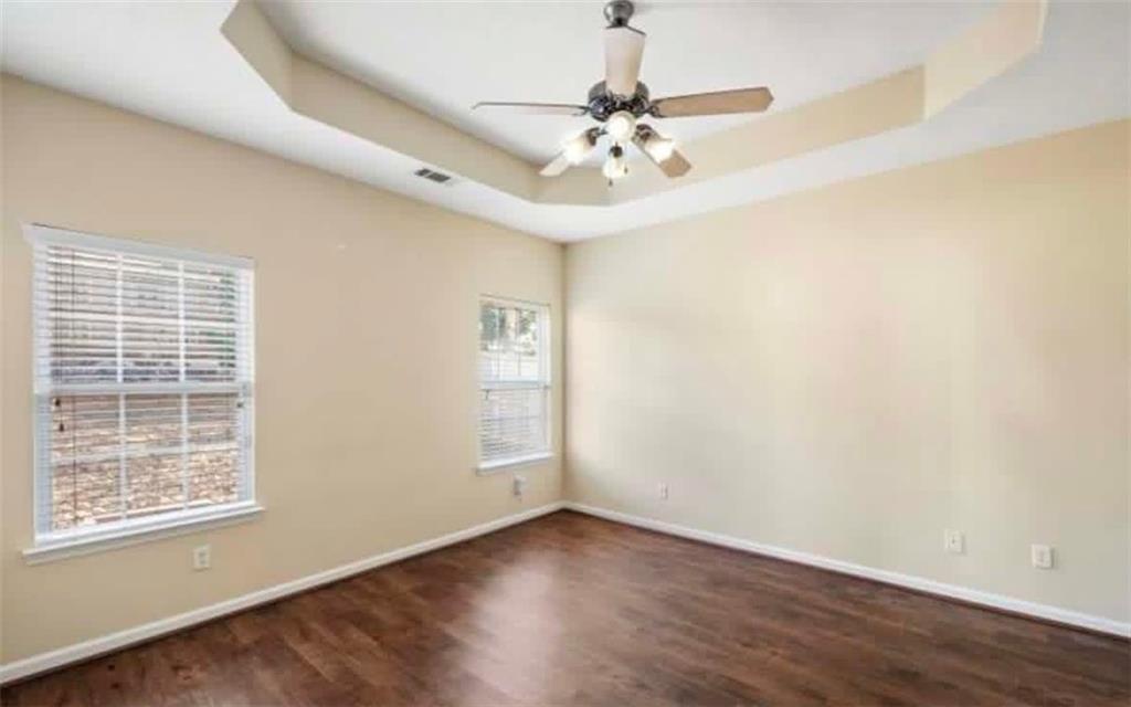 2162 Capella Circle Southwest Atlanta, GA 30331 - Photo 7 of 11 an empty room with wooden floor chandelier fan and windows