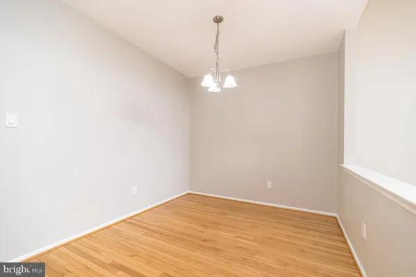 a view of a room with wooden floor and chandelier