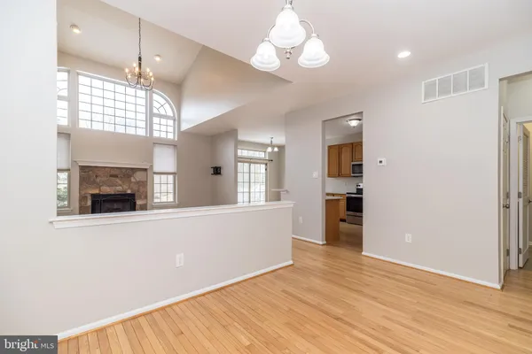 an empty room with windows a fireplace and wooden floor