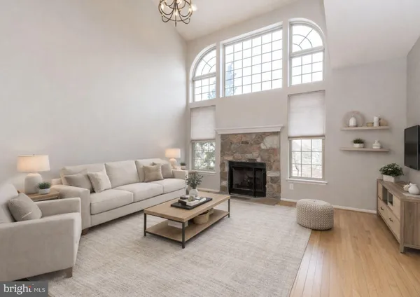 an empty room with wooden floor fireplace and windows