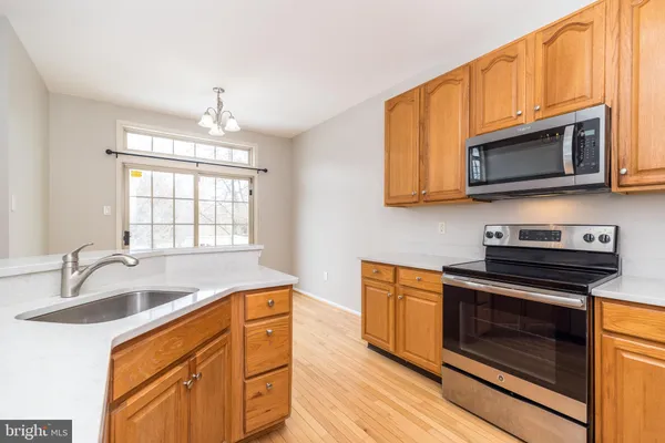 a kitchen with stainless steel appliances a refrigerator sink and microwave