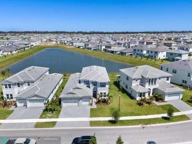 an aerial view of residential houses with outdoor space and ocean view